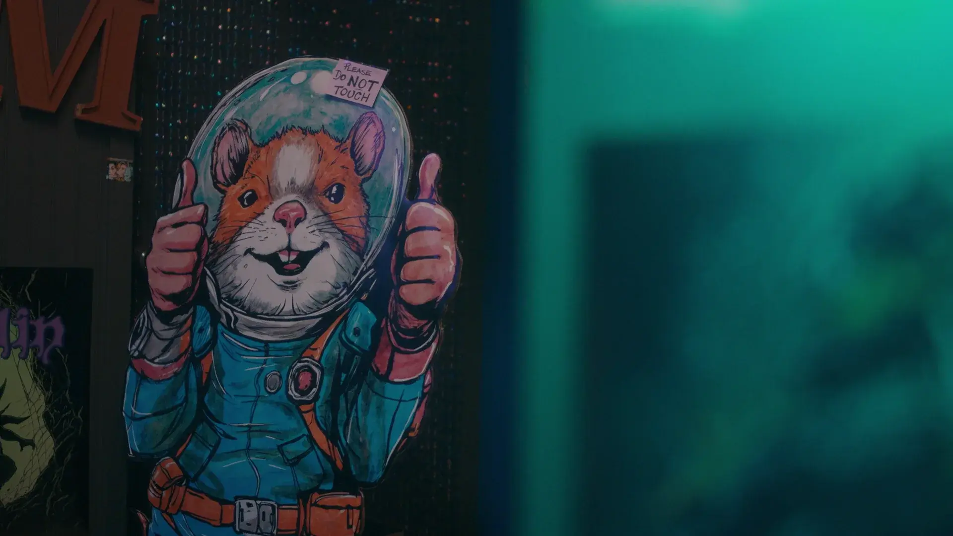 A painted cut-out of a smiling hamster astronaut giving two thumbs up, inside the comic shop